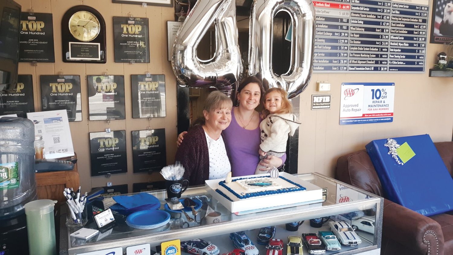 MANY CELEBRATIONS: June Carrara (Dave’s wife), stands with her daughter-in-law Michelle Carrara, and grandson Diamantino to celebrate the 40th Anniversary of Carrara’s Auto Clinic on  Oct. 15, 2019.
